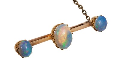 Lot 673 - Late Victorian opal bar brooch with three oval opal cabochons in gold claw setting on a knife edge bar, 42mm.