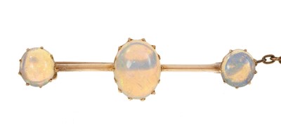 Lot 673 - Late Victorian opal bar brooch with three oval opal cabochons in gold claw setting on a knife edge bar, 42mm.