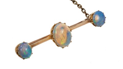 Lot 673 - Late Victorian opal bar brooch with three oval opal cabochons in gold claw setting on a knife edge bar, 42mm.