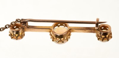Lot 673 - Late Victorian opal bar brooch with three oval opal cabochons in gold claw setting on a knife edge bar, 42mm.