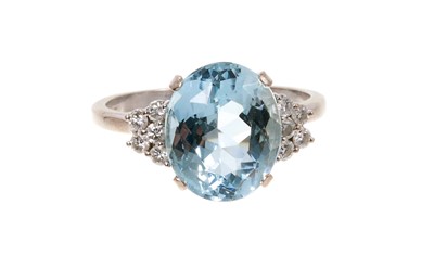 Lot 685 - Aquamarine and diamond ring with an oval mixed cut aquamarine measuring approximately 13mm x 10.7mm x 7mm, in four claw setting flanked by ten brilliant cut diamonds to the shoulders on 18ct white...