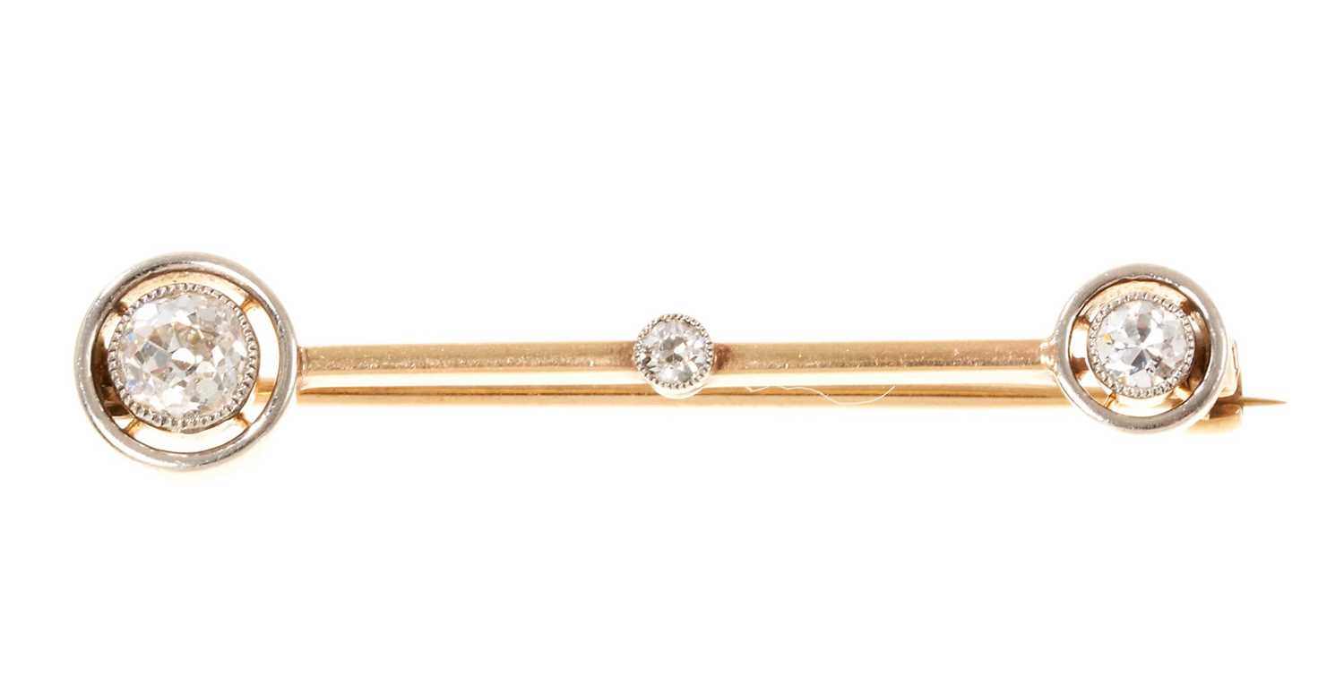Lot 691 - Edwardian diamond comet with three old cut diamonds in platinum setting on a gold bar, estimated total diamond weight approximately 0.45-0.50cts. Length 39mm
