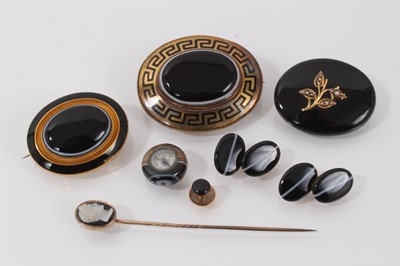 Lot 688 - A group of Victorian agate jewellery to include a carved agate cameo stick pin, a pair of 9ct gold and banded agate cufflinks, two gold black enamel and banded agate brooches, another black agate b...