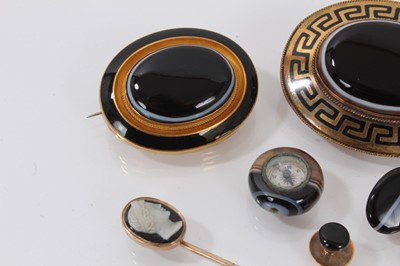 Lot 688 - A group of Victorian agate jewellery to include a carved agate cameo stick pin, a pair of 9ct gold and banded agate cufflinks, two gold black enamel and banded agate brooches, another black agate b...