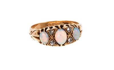 Lot 675 - Edwardian opal and diamond ring with three opal cabochons interspaced by four old cut diamonds in carved gold claw setting on 18ct gold shank, Birmingham 1910. Ring size N½.