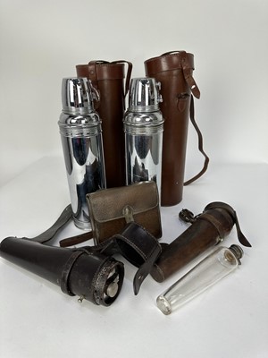 Lot 1253 - Two leather cased saddle flasks, a leather sandwich case (lacking) with glass flask and two vintage Thermos flasks in leather cases