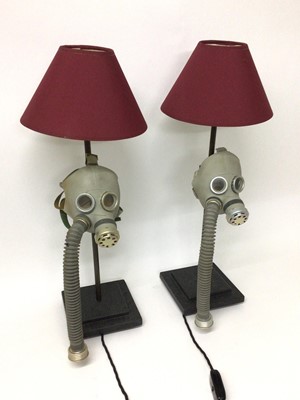 Lot 84 - A pair of child's gas masks converted to table lamps, with blue LED lights fitted behind each eyepiece, 66cm high