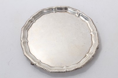 Lot 520 - George V silver salver of circular form, with gadrooned border, raised on three hoof feet, (London 1910), maker Stewart Dawson Ltd, 13ozs, 20cm in diameter.