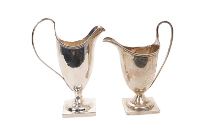 Lot 516 - George III silver cream jug of helmet form, raised on a square pedestal base, (London 1784), together with a similar Edwardian example (London 1909), maker Mappin & Webb, 15.5cm and 14cm in height...