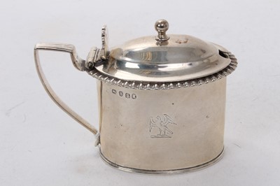 Lot 530 - George III silver mustard pot of oval form with engraved armorial and gadrooned border, hinged lid and blue glass liner to interior, (London 1812), makers mark rubbed, 3ozs, 11cm in length