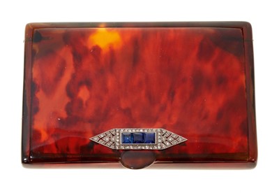 Lot 786 - Art Deco tortoiseshell cigarette case with an applied sapphire and diamond plaque to the thumb piece, 76mm x 60mm.