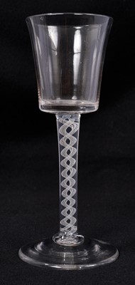 Lot 313 - A Georgian wine glass, c. 1760, the slightly flared bucket bowl over an opaque twist stem consisting of a pair of spiral lace tapes, over a conical foot, 17cm high