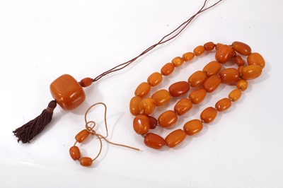 Lot 847 - Amber necklace with a string of graduated butterscotch amber beads together with a larger amber bead pendant necklace