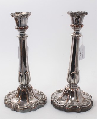 Lot 597 - Pair early 19th century Old Sheffield Plate candlesticks, with octagonal leaf mounted stems, urn candle holders and separate sconces, on scroll decorated pedestal bases (unmarked). 28cm overall.