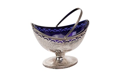 Lot 553 - George III silver swing handled sugar basket of boat shaped form, with engraved decoration and pierced border, on an oval pedestal base, blue glass liner (London 1791) maker F.P. All at approximate...