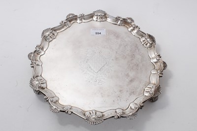 Lot 554 - Early George III silver salver of hexagonal form, with shell and scroll border and engraved centre, on three leaf scroll feet (London 1760) Ebenezer Coker. All at approximately 28ozs. 32cm across.