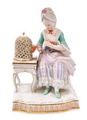 Lot 327 - A 19th century Meissen lace figure of a lady feeding her pet parrot, polychrome decorated, crossed swords mark with incised model number 'E4', 14.5cm high