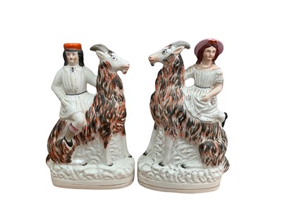 Lot 333 - A large pair of Victorian Staffordshire figures of a lady and gentleman riding goats, 33cm high, together with a large pair of Staffordshire spaniels