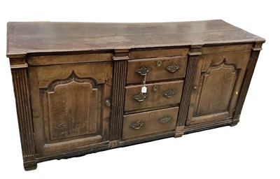 Lot 1627 - George III dresser base, with three central drawers flanked by fluted projecting columns and fielded panel doors, 177cm wide x 57cm deep x 83cm high