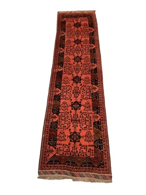 Lot 1715 - Afghan runner, with repeat foliate and medallion motif on brick red ground, in multiple borders, 381 x 90cm