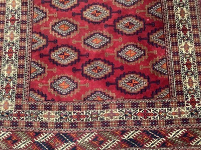 Lot 1716 - Tekke style rug, with repeat quartered medallions on claret ground and in multiple geometric borders, 186 x 116cm