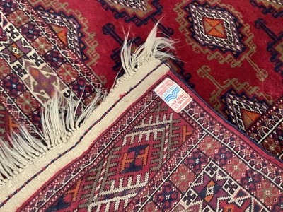 Lot 1716 - Tekke style rug, with repeat quartered medallions on claret ground and in multiple geometric borders, 186 x 116cm