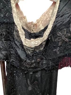 Lot 2104 - Edwardian evening dress in black satin with beaded net overlay, high waist and asymmetric draping and fringing.