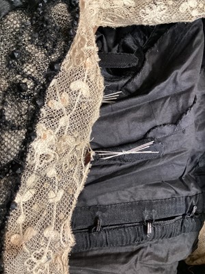 Lot 2104 - Edwardian evening dress in black satin with beaded net overlay, high waist and asymmetric draping and fringing.