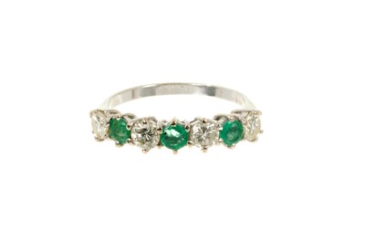 Lot 540 - Emerald and diamond eternity ring with a half hoop of three round mixed cut emeralds and three brilliant cut diamonds in 18ct white gold setting