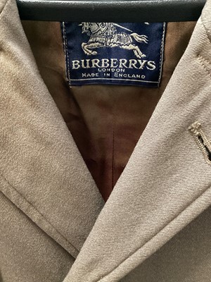 Lot 2110 - Early Burberrys men's gabardine mac with concealed buttons, button tab to cuffs and two-tone lining, Aquascutum men's grey herringbone wool overcoat and a grey pinstripe three piece suit , trouser...