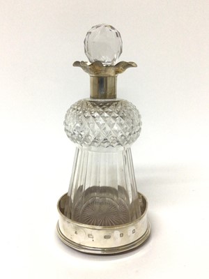 Lot 17 - Silver mounted cut glass lidded thistle decanter, housed in a modern silver wine coaster