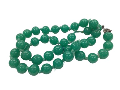 Lot 1018 - Green jade ring, green hard stone bead necklace, 48cm long and an unmounted oval mixed cut citrine