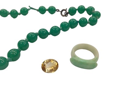 Lot 1018 - Green jade ring, green hard stone bead necklace, 48cm long and an unmounted oval mixed cut citrine