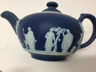 Lot 17 - A group of five 19th century English teapots, including one dark blue Wedgwood jasperware, one lilac jasperware, and three other relief-moulded examples