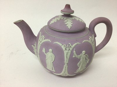 Lot 17 - A group of five 19th century English teapots, including one dark blue Wedgwood jasperware, one lilac jasperware, and three other relief-moulded examples