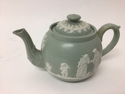 Lot 17 - A group of five 19th century English teapots, including one dark blue Wedgwood jasperware, one lilac jasperware, and three other relief-moulded examples