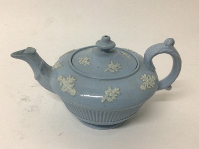 Lot 17 - A group of five 19th century English teapots, including one dark blue Wedgwood jasperware, one lilac jasperware, and three other relief-moulded examples