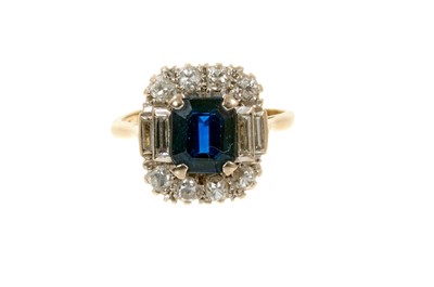 Lot 499 - Sapphire and diamond cluster ring with a rectangular cut-cornered step cut blue sapphire flanked by graduated baguette cut diamonds and eight old cut diamonds in 18ct gold setting