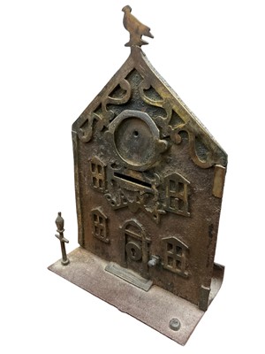 Lot 2561 - Victorian brass and iron money box in the form of a bank with brass door and windows, lamp posts (one missing) and a bird on the roof. 20 cm overall height.