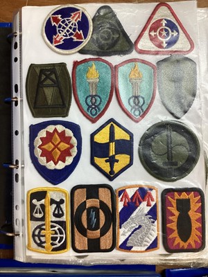 Lot 763 - Four albums of American Air Force, US Army and US Navy military cloth and metal badges (4 albums)