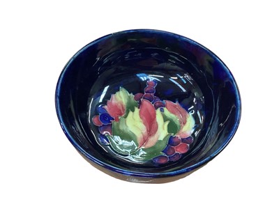 Lot 1260 - Moorcroft pottery bowl with leaf and berry decoration on blue ground, impressed marks to base