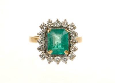 Lot 449 - Emerald and diamond cluster ring with a rectangular step cut emerald surrounded by 16 brilliant cut diamonds in claw setting on 18ct gold shank, London 1977.