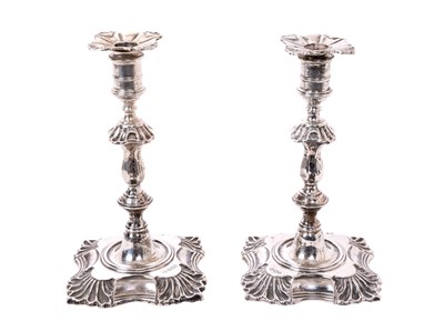 Lot 92 - Pair of Georgian-style silver taper sticks of typical form on foliate shell bases (Sheffield 1900), 12.5cm high
