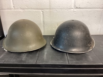 Lot 827 - 1950’s British military MK III steel helmet with black camouflage finish, with liner and chin strap, together with another similar MK III steel helmet (2)