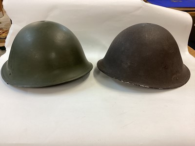 Lot 829 - 1950’s British military MK III steel helmet with camouflage finish, with liner and chin strap, together with another similar MK III steel helmet (2)