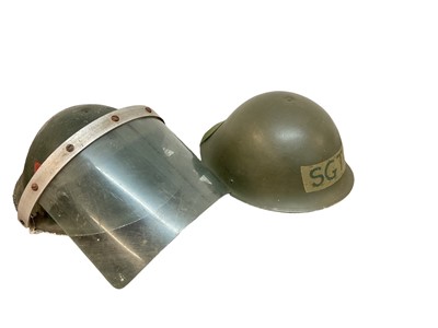 Lot 831 - British military MK III steel helmet with camouflage finish, with liner and chin strap, together with another similar MK III steel helmet, with visor (possibly for Northern Ireland service) (2)