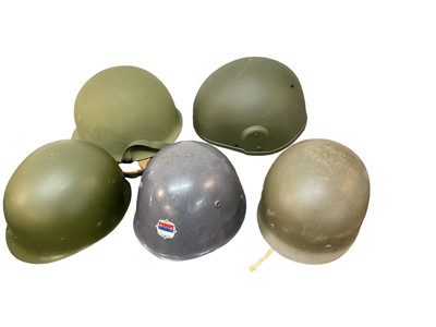 Lot 833 - American M1 steel helmet complete with liner and chinstrap, together with four other various military helmets (5)