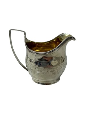 Lot 36 - George III silver helmet shaped cream jug with gilded interior, engraved borders and armorial, (London 1804), 2.7ozs