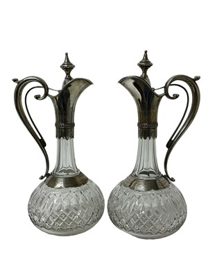 Lot 135 - Pair elegant late 19th century Continental white metal mounted and cut glass claret jugs of classical form with sprung hinged covers, engraved mounts and slice and hobnail cut bodies 34cm high