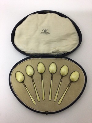 Lot 122 - A cased set of six yellow-enamelled and silver-gilt teaspoons, Birmingham 1922